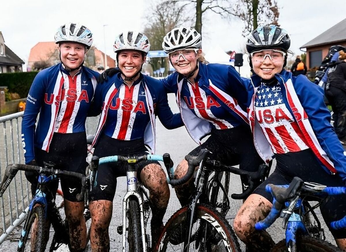 Group of female cyclocross racers smiling together after a race.