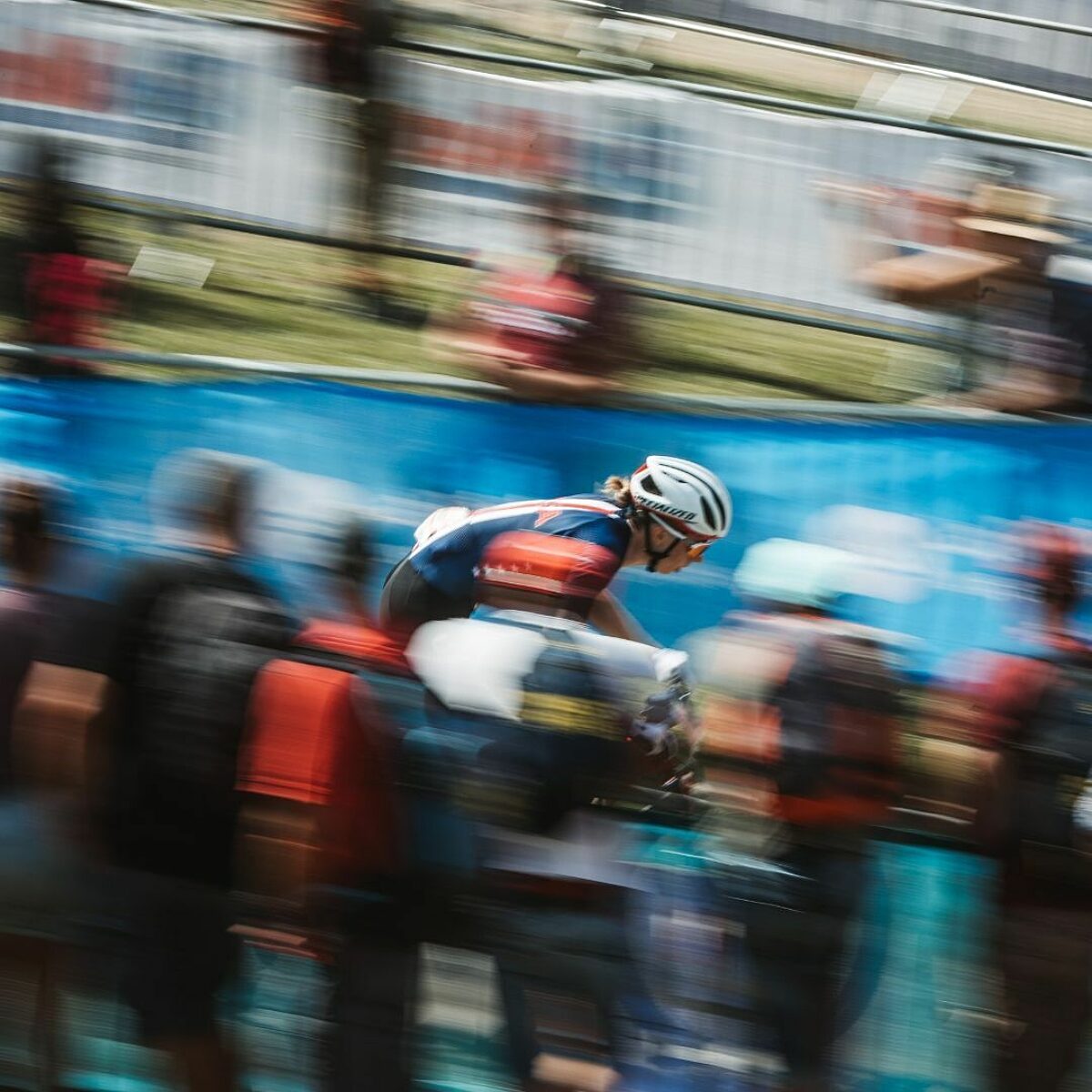 Gravel racer, mid-race the background is blurred showing the athlete's speed.