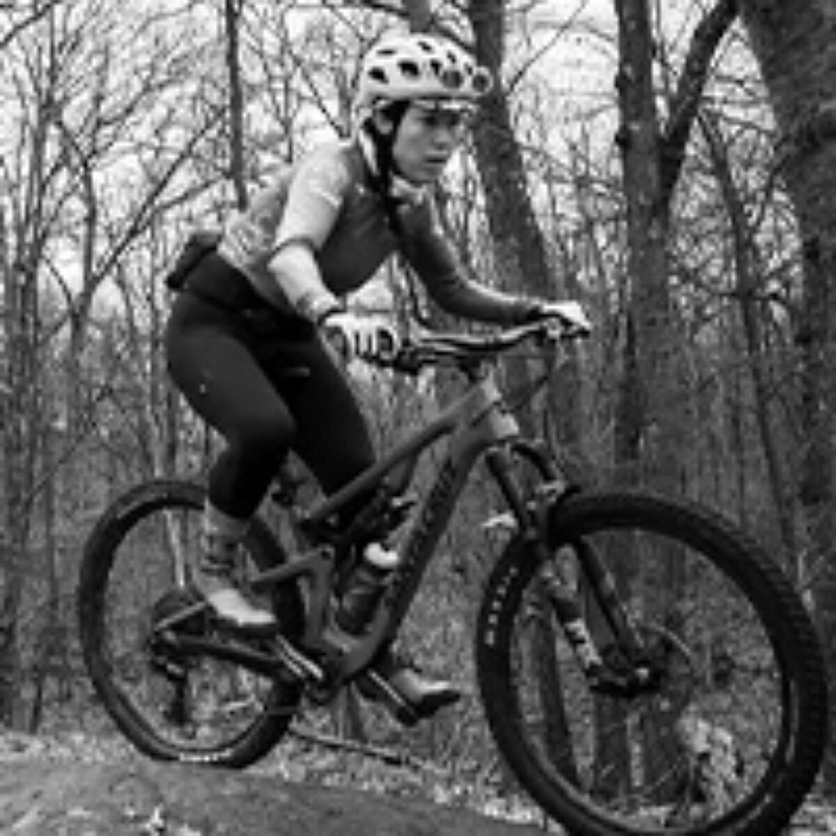 Lucia Deng riding her mountain bike in the woods
