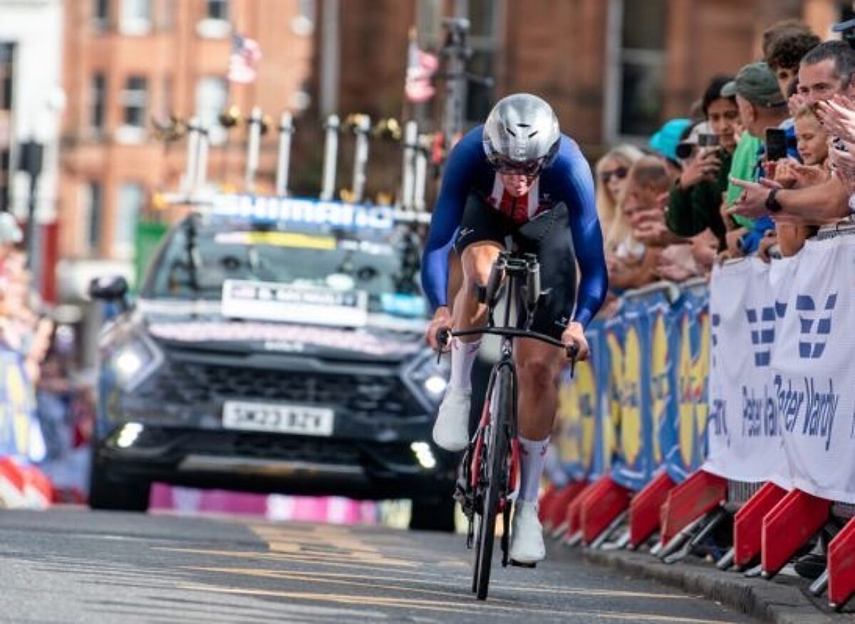 A USA Cycling bike racer being followed by a chase car in a time trial race