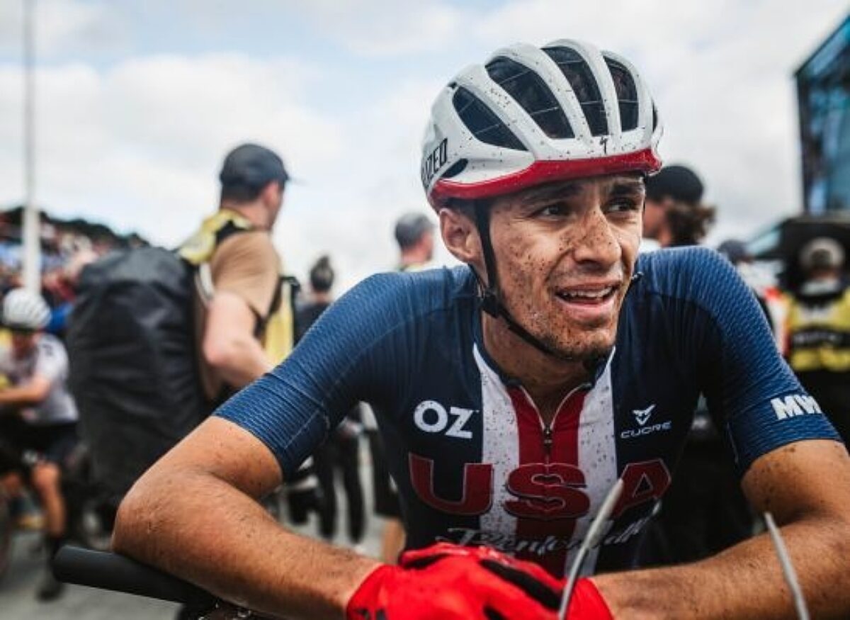 A USA Cycling athlete resting on a race barricade post race