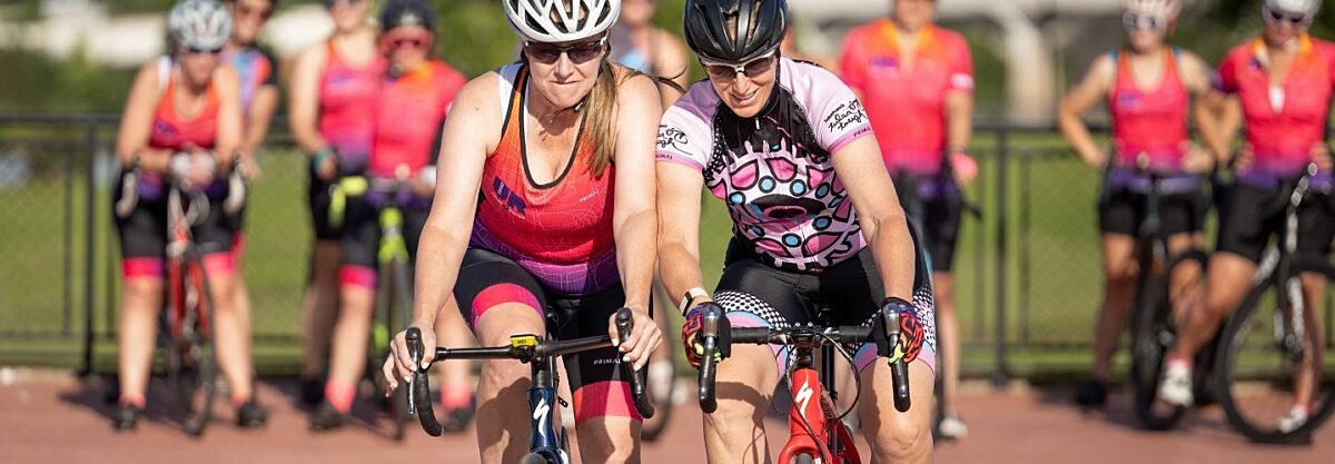 Female cyclists racing each other and going shoulder to shoulder in a training drill.